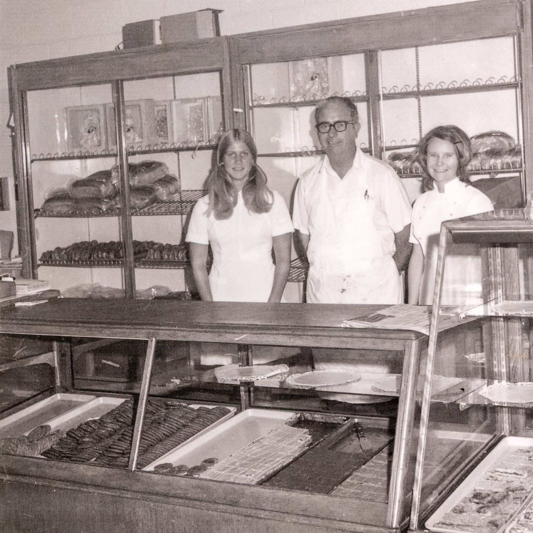 Amon & two employees behind the counter, older photograph