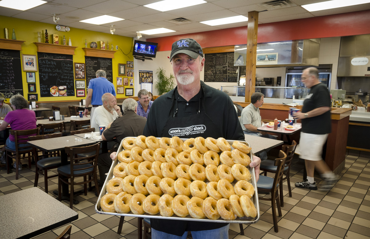 Recent photo of Doug Stephens holding a large tray of glazed donuts