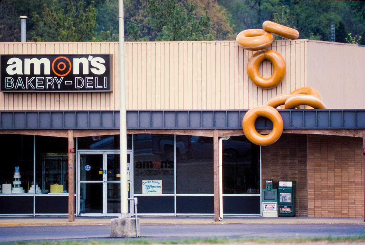 Exterior of Amon's Bakery with large Huge donut decorations tumbling from the roof