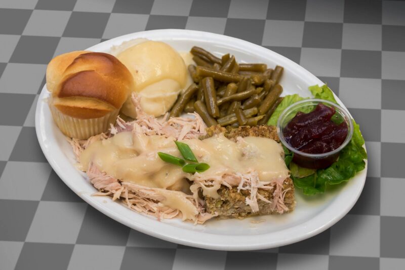 Turkey & Dressing with green beans, mashed potatoes & gravy, and butterfly roll.